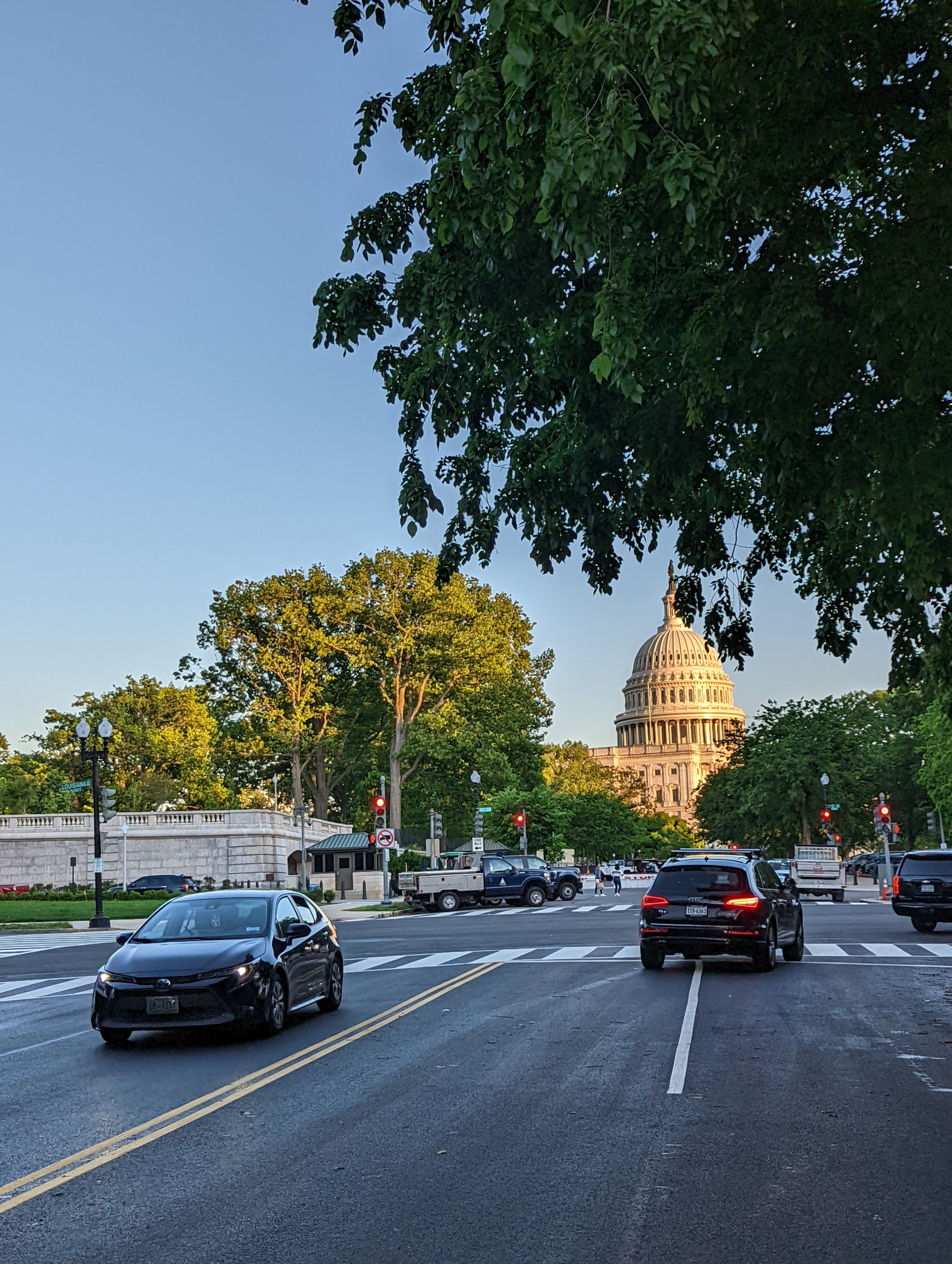 Cars traveling on asphalt roadway with U.S. Capitol building in background in Washington, D.C.